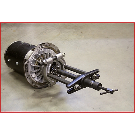 Ein Maschinenteil mit einem schwarzen Gehäuse, einem silberfarbenen Propeller und einem komplexen Mechanismus. Der Hintergrund ist grau.